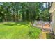 Expansive backyard featuring a deck, lush lawn, disc golf, and mature trees at 3806 Lochnora Pkwy, Durham, NC 27705