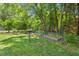 Expansive backyard featuring a raised garden and disc golf basket amid lush greenery and mature trees at 3806 Lochnora Pkwy, Durham, NC 27705