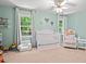 Bedroom bedroom with crib, rocking chair, and soft mint-green walls creating a cozy space at 3806 Lochnora Pkwy, Durham, NC 27705