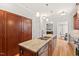 Kitchen island featuring a stainless steel sink, granite countertops, and custom wood cabinetry at 3806 Lochnora Pkwy, Durham, NC 27705
