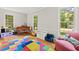 Bright playroom featuring hardwood floors, large windows, comfortable seating, and colorful play mats at 3806 Lochnora Pkwy, Durham, NC 27705