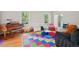 Bright playroom featuring hardwood floors, colorful mats, and ample natural light from large windows at 3806 Lochnora Pkwy, Durham, NC 27705