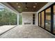 Covered patio with stone fireplace, built-in shelving, and retractable screen windows at 4 Rainforest Pl, Apex, NC 27523
