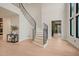 Spacious foyer with curved staircase and views into other rooms of the house at 4 Rainforest Pl, Apex, NC 27523