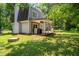 Backyard with a patio, green lawn, brick chimney, and wooded area at 4001 Pin Oak Rd, Raleigh, NC 27604