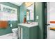 Bathroom featuring marble floors, green walls, and white fixtures and vanity at 4001 Pin Oak Rd, Raleigh, NC 27604