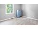 Bedroom with gray walls, a window, and light-colored floors with a blue dresser at 4001 Pin Oak Rd, Raleigh, NC 27604