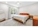 Bright bedroom with a window, ceiling fan, mirror, and wooden furniture at 4001 Pin Oak Rd, Raleigh, NC 27604