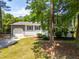 Inviting exterior with a mix of gray siding and painted brick, complemented by mature trees and landscaping at 4001 Pin Oak Rd, Raleigh, NC 27604