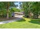 Charming two-story home features a well-manicured lawn, lush trees, and a long driveway leading to a garage at 4001 Pin Oak Rd, Raleigh, NC 27604