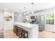 Bright kitchen boasts a large island with seating, white cabinets, stainless steel appliances, and modern finishes at 4001 Pin Oak Rd, Raleigh, NC 27604