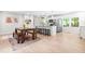 Bright kitchen featuring stainless steel appliances, a large island, and an adjacent dining area with wooden table and benches at 4001 Pin Oak Rd, Raleigh, NC 27604