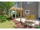 Covered patio with a grill, seating, mulched area, and attached string lights at 4001 Pin Oak Rd, Raleigh, NC 27604