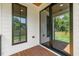 Covered back porch with wood flooring, white trim, a black framed window and sliding glass door at 411 Bon Air Ave, Durham, NC 27704