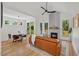 Bright living room with hardwood floors, fireplace, modern fan, and a view into the dining area at 411 Bon Air Ave, Durham, NC 27704