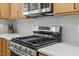Close-up of stainless steel stove in kitchen with modern countertops and backsplash at 411 Bon Air Ave, Durham, NC 27704