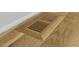 Close-up of a wooden vent in a hardwood floor showcases quality craftsmanship and seamless design at 411 Bon Air Ave, Durham, NC 27704