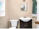 Compact bathroom featuring a toilet, a modern sink, and a framed mirror above the sink at 4536 Massey Rd, Zebulon, NC 27597