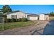White garage with metal roof, driveway, manicured landscaping, and a storage shed at 4536 Massey Rd, Zebulon, NC 27597