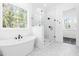 Modern bathroom featuring a freestanding tub, a glass-enclosed shower, and marble floors at 50 Farmstead Ct, Wendell, NC 27591