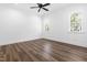Bright bedroom featuring hardwood floors, white walls, a ceiling fan, and two windows at 50 Farmstead Ct, Wendell, NC 27591