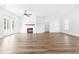 Bright living room featuring hardwood floors, a white brick fireplace, built-in shelving, and french doors at 50 Farmstead Ct, Wendell, NC 27591
