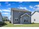 Two-story home with gray siding, a patio, and a well-manicured lawn under a bright blue sky at 520 Oak Holly Ln, Zebulon, NC 27597