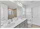 Bathroom featuring dual sinks, a large mirror, and a tiled shower at 520 Oak Holly Ln, Zebulon, NC 27597