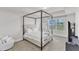 Bright bedroom featuring a canopy bed, neutral tones, and window views at 520 Oak Holly Ln, Zebulon, NC 27597