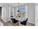 Cozy dining area featuring a modern table and comfortable chairs, bathed in natural light from large windows at 520 Oak Holly Ln, Zebulon, NC 27597