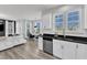 Bright, modern kitchen flows into the living area, featuring white cabinets, black countertops, and stainless steel appliances at 520 Oak Holly Ln, Zebulon, NC 27597