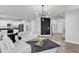 Open concept living room with modern lighting, sleek flooring, and a comfortable sofa adjacent to the kitchen at 520 Oak Holly Ln, Zebulon, NC 27597