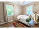 Cozy bedroom with two bright windows, neutral walls, and wood-look flooring at 522 E Club Blvd, Durham, NC 27704