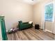 Cozy bedroom with a green futon, natural light, and wood-look flooring at 522 E Club Blvd, Durham, NC 27704