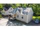 A cozy tan home with gray roof and front porch nestled among mature trees and next to another similar-style home at 522 E Club Blvd, Durham, NC 27704