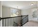 Stairway landing featuring a black metal banister and hanging chandelier at 550 Spring Flowers Dr, Cameron, NC 28326