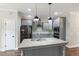 A contemporary kitchen featuring a large island with granite countertops, stainless steel appliances, and gray cabinets at 550 Spring Flowers Dr, Cameron, NC 28326