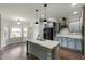 Bright kitchen featuring a large island with granite countertops, gray cabinets, and modern black appliances at 550 Spring Flowers Dr, Cameron, NC 28326