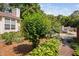 A home nestled amongst mature trees with a well-manicured lawn and landscaped walkway at 5911 Westcreek Pl, Raleigh, NC 27606