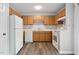 Functional kitchen showcasing wood cabinets, a white refrigerator, and standard white appliances at 5911 Westcreek Pl, Raleigh, NC 27606