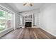 Spacious living room showcasing a cozy fireplace with white built-ins, modern ceiling fan, and sleek flooring at 5911 Westcreek Pl, Raleigh, NC 27606