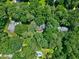 Stunning aerial view of the home with a pool surrounded by lush trees and greenery, offering privacy and a serene setting at 608 Misty Isle Pl, Raleigh, NC 27615