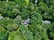 High angle shot of wooded acreage with house providing a sense of natural seclusion at 608 Misty Isle Pl, Raleigh, NC 27615