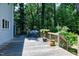 Outdoor deck with seating, a grill, and views of the wooded backyard at 608 Misty Isle Pl, Raleigh, NC 27615