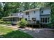 The back exterior of the house features a deck, a screened-in porch, and a well-maintained lawn at 608 Misty Isle Pl, Raleigh, NC 27615