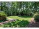 Expansive backyard with lush green grass and mature trees and landscaping at 608 Misty Isle Pl, Raleigh, NC 27615