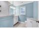Light and airy bathroom featuring dual vanities, a glass shower enclosure, and blue accent walls at 608 Misty Isle Pl, Raleigh, NC 27615