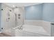 Bright bathroom featuring a soaking tub and a glass enclosed shower at 608 Misty Isle Pl, Raleigh, NC 27615