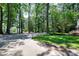 Long paved driveway shaded by mature trees leads to the beautiful home at 608 Misty Isle Pl, Raleigh, NC 27615