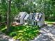 Charming two-story home with white exterior, black shutters, manicured lawn and a wooded backdrop at 608 Misty Isle Pl, Raleigh, NC 27615